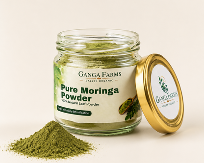 Jar of Ganga Farms Pure Moringa Powder with open lid on a beige background